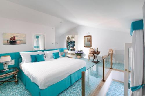 a bedroom with a large bed with blue accents at De Pando Panoramic Suites 1096 in Scala