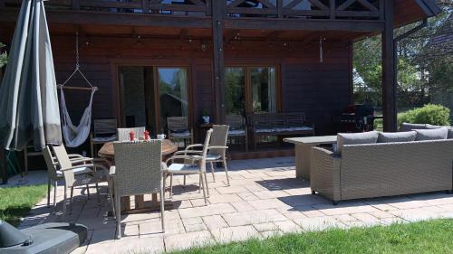 a patio with a table and chairs and an umbrella at Lavender Cottage in Sucha Rzeczka