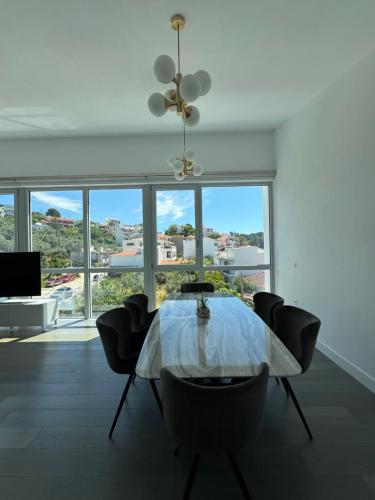 a dining room with a table and chairs and windows at Anemoni Beach Hotel in Skiathos Town