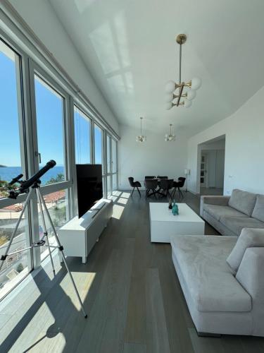 a living room with white furniture and large windows at Anemoni Beach Hotel in Skiathos Town