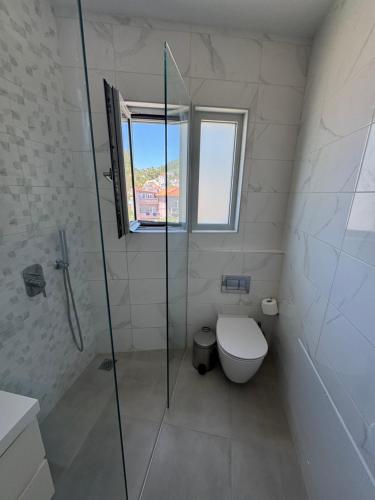 a bathroom with a toilet and a glass shower at Anemoni Beach Hotel in Skiathos Town