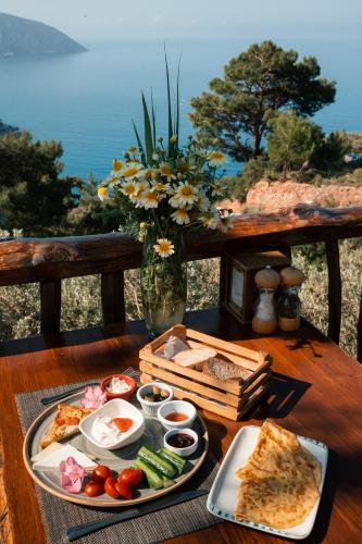 a table with a tray of food on a table with the view at Olive Garden Kabak in Faralya