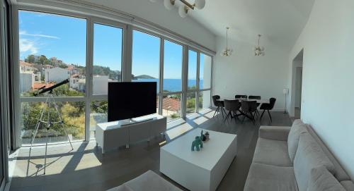 a living room with a couch and a tv and a table at Anemoni Beach Hotel in Skiathos Town