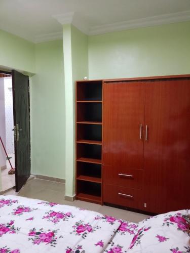 a bedroom with a bed and a wooden cabinet at Farmaz Apartment in Agun