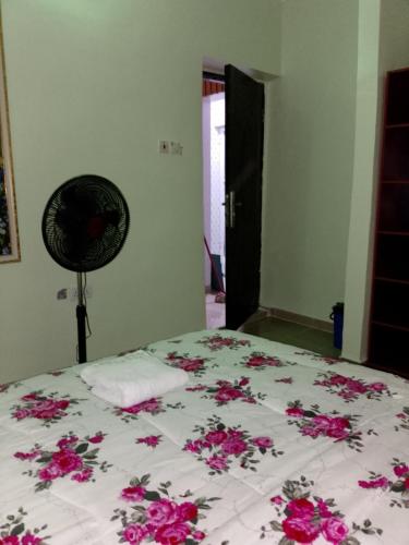 a bedroom with a bed with pink flowers on it at Farmaz Apartment in Agun
