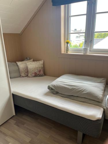 a bed in a small room with a window at Sjåen Panorama in Kragerø