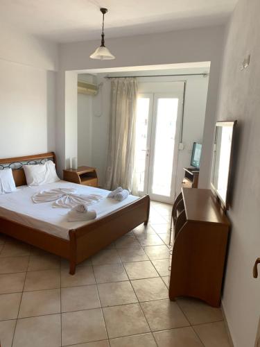 a bedroom with a bed and a tv and a window at City Center in Sarandë