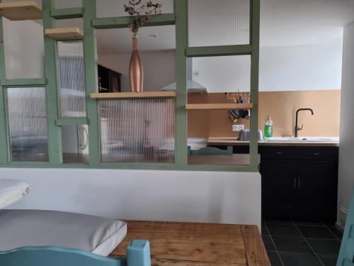 - une cuisine avec des murs verts et blancs et un évier dans l'établissement Gîte chez passet, à Montgaillard