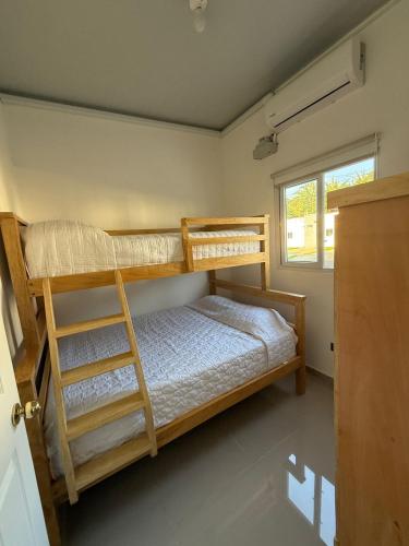 a bedroom with two bunk beds and a window at Maadi-Tiny House-Los Ausoles in Ahuachapán