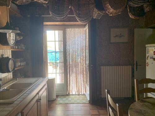 a kitchen with a large window and a kitchen table at Le Paradis Saint Frajou, very beautiful Villa 200m2 swimming pool and style in Saint-Frajou