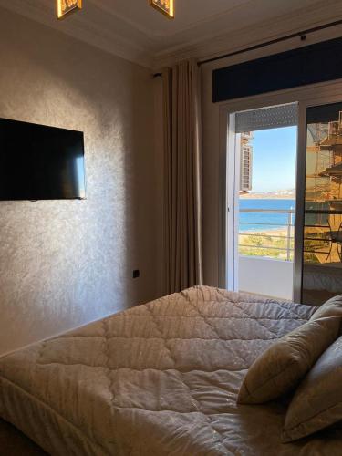 a bedroom with a large bed with a view of the ocean at luxury sea view apartment in Tangier