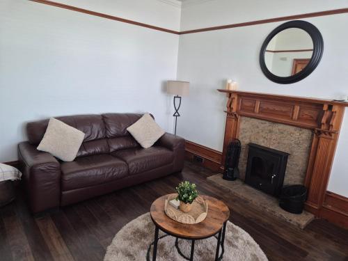 a living room with a couch and a fireplace at Dalwhinnie in Portessie
