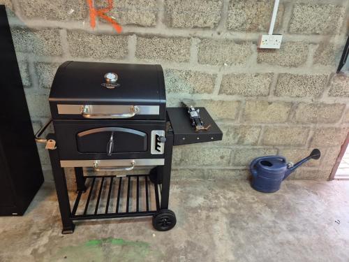 a grill sitting on a cart next to a brick wall at Dalwhinnie in Portessie