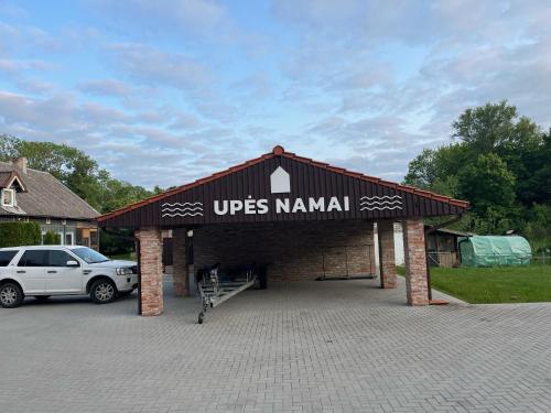 a garage with a car parked in a driveway at Apartamentai ,,Upės Namai'' in Šilutė