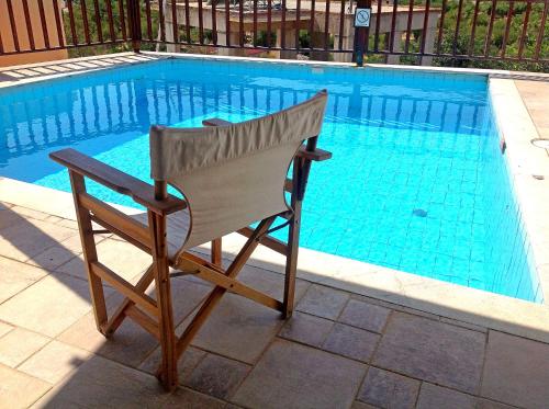 a chair sitting in front of a swimming pool at Elounda Traditional Homes of Crete in Elounda