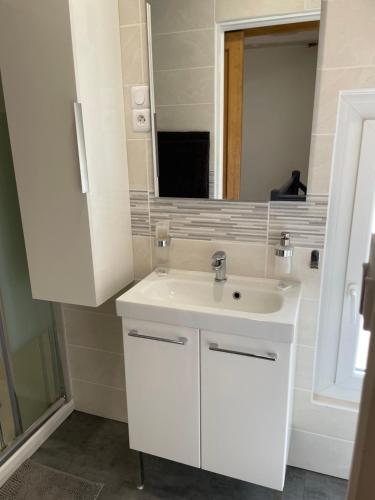 une salle de bain avec un lavabo blanc et un miroir dans l'établissement Maison de village proche mer, à Sainte-Marie-la-Mer