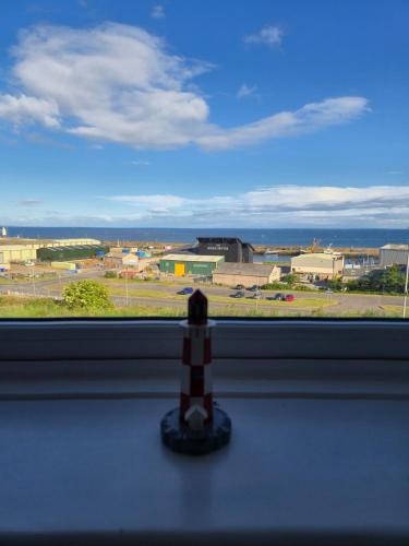 a toy figurine sitting on a window sill looking out at an airport at Dalwhinnie in Portessie