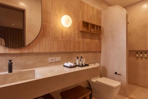 a bathroom with a sink and a toilet and a mirror at Casa Cunda in Oaxaca City