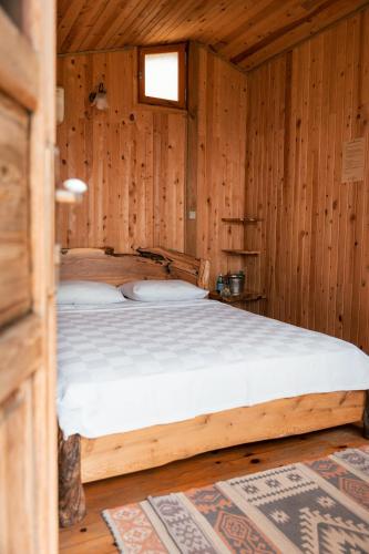 a bedroom with a bed in a wooden room at Olive Garden Kabak in Faralya