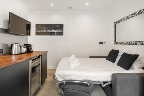 une petite chambre avec un lit et une télévision dans l'établissement Studio Climatisé - Ultra Lumineux - Proche Paris, à Saint-Maurice