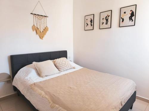 a bedroom with a bed with four pictures on the wall at Yam Suf Roof in Eilat