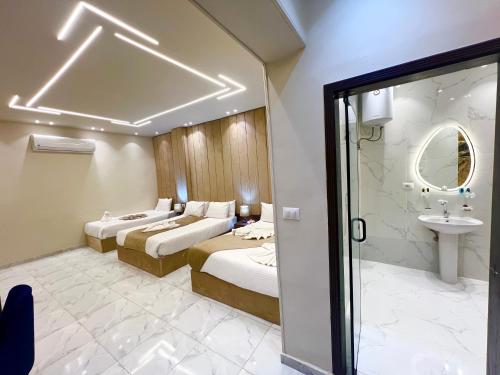 a hotel room with two beds and a sink at New Jazal pyramids view in Cairo
