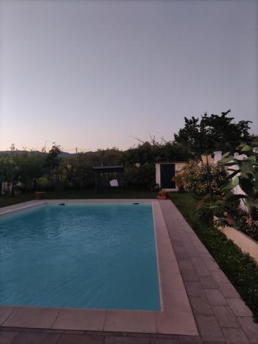 a swimming pool in a yard next to a garden at Appartamenti Ca'Melia in Sarzana