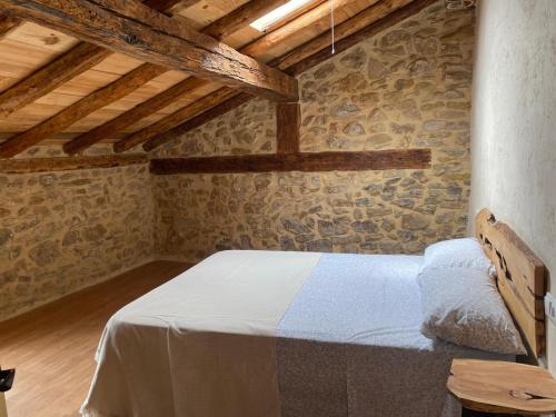 a bedroom with a bed in a stone wall at La Sabina in Terriente