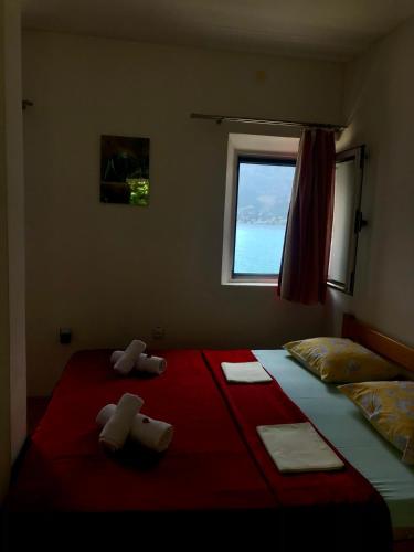 a bedroom with a large bed with towels on it at Apartments Vila San in Kamenari