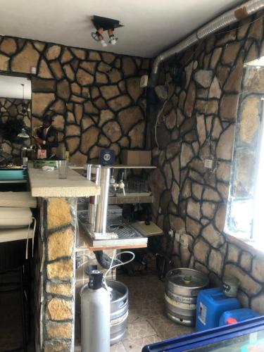 a room with a stone wall and a kitchen at Apartments Vila San in Kamenari