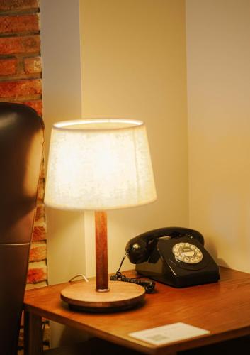 a lamp on a desk next to a telephone at Boutique Hotel Kviria in Tʼelavi