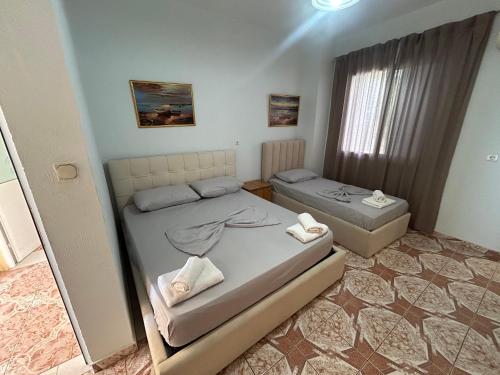 a small bedroom with two beds and a window at Vila 23 in Dhërmi