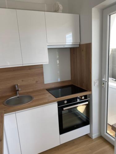 a kitchen with white cabinets and a sink at Vacances à la mer in Cagnes-sur-Mer