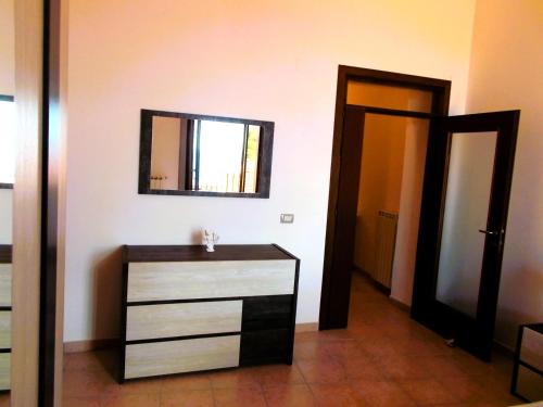 a bathroom with a dresser and a mirror on the wall at Aurora - Discover Cilento in Pisciotta