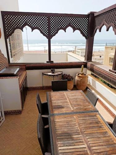 a dining room with a table and a view of the beach at Maison ASSIA in Zaouit Aglou