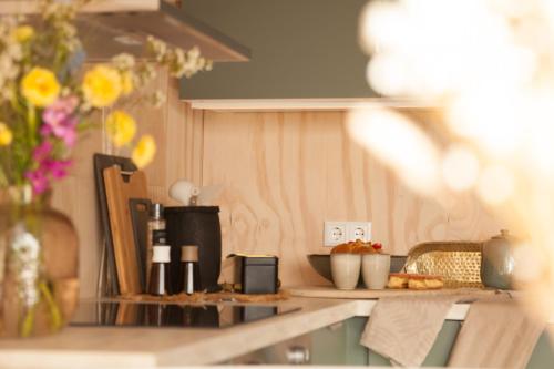 a kitchen counter with a table with food on it at Ecohome Golf 8pers and baby Zeezand Recreatie in 't Zand