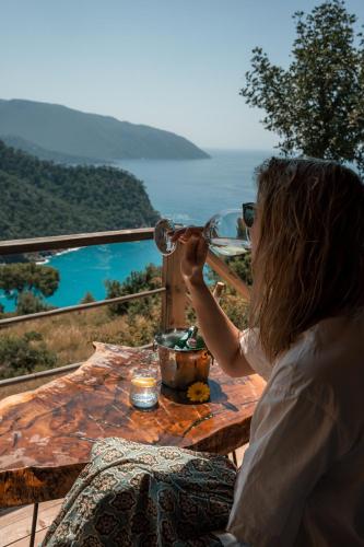 a woman sitting at a table drinking a glass of wine at Olive Garden Kabak in Faralya