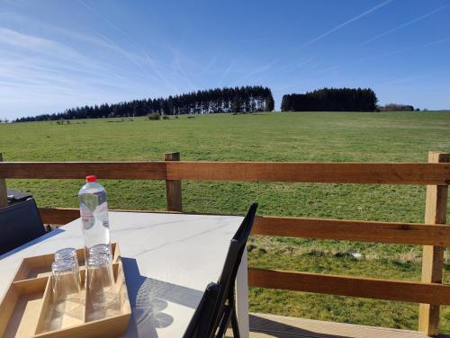 a table with a bottle of water sitting on top of a field at Terre - Le - Sart in Neufchâteau