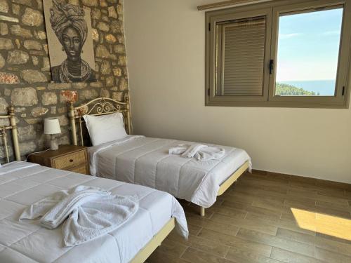 two beds in a room with a painting on the wall at Lavender House 1 - Agios Nikitas in Agios Nikitas