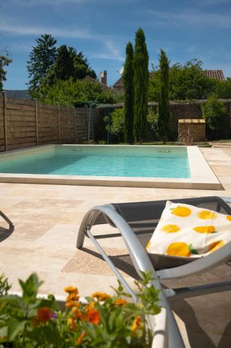 une chaise à côté d'une piscine avec une table dans l'établissement L'Abri de Malaucène - Gîte Cycliste, à Malaucène