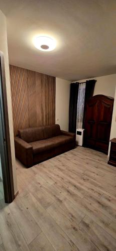 a living room with a brown couch in a room at SLEEP & GO Pisa in Pisa