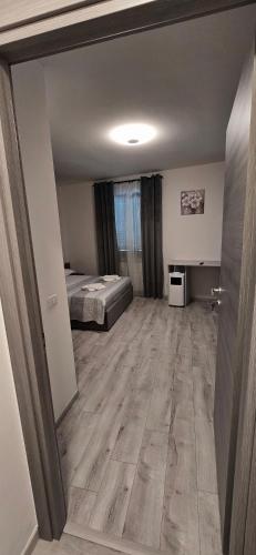 a room with a bed and a room with a wooden floor at SLEEP & GO Pisa in Pisa