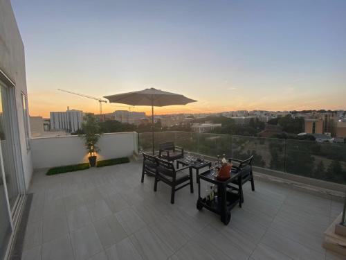 a balcony with two tables and an umbrella at Sailsbury in Msieraħ