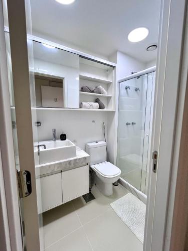 a bathroom with a toilet and a sink and a shower at Suíte com jardim e piscina na Barra Olímpica RJ in Rio de Janeiro