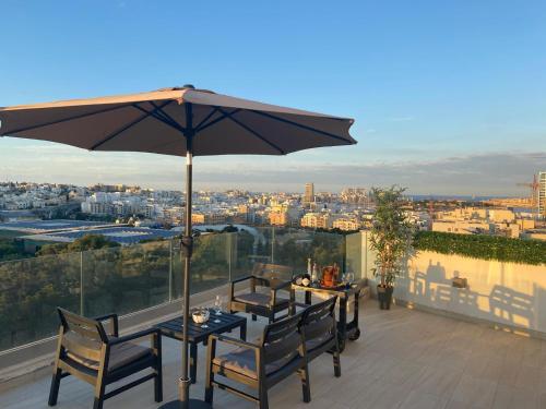 a patio with two tables and an umbrella at Sailsbury in Msieraħ