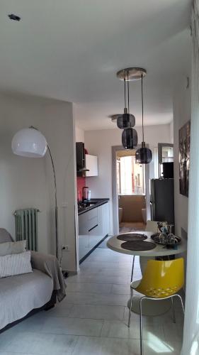 a living room with a table and a yellow chair at Novecento in Bertinoro