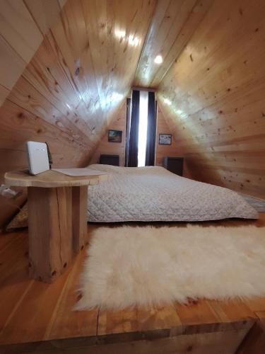 a bedroom with a bed and a table with a laptop on it at Planinska kuca-Jovanovic! in Kremna