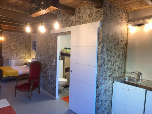 - une cuisine avec un évier et une table dans une chambre dans l'établissement L'Antre d'Eux la pause évasion sur la route des vacances, à Mont-lʼÉtroit