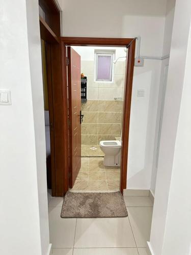 a bathroom with a toilet and a shower with a door at The KONGONI PLACE in Gatunga