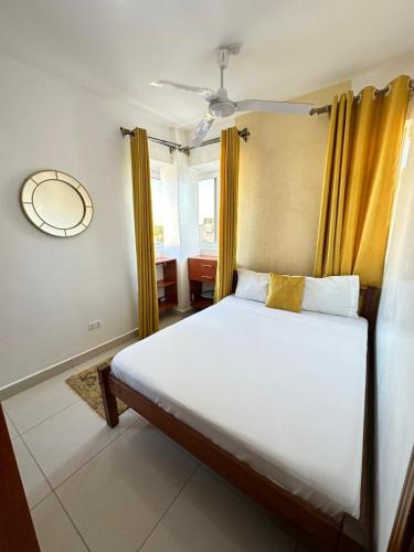 a bedroom with a large bed with yellow curtains at The KONGONI PLACE in Gatunga